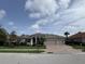 Charming single-story home featuring a well-manicured lawn, mature landscaping and a brick driveway at 10509 Winding Stream Way, Bradenton, FL 34212