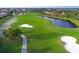 An aerial view of a golf course with lush greenery, sand traps, and water features at 10509 Winding Stream Way, Bradenton, FL 34212