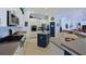 Kitchen with stainless steel appliances, white cabinetry, a navy island and open concept to other rooms at 10509 Winding Stream Way, Bradenton, FL 34212