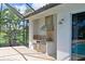 Outdoor kitchen with built-in grill, sink, and storage, perfect for poolside entertaining at 10509 Winding Stream Way, Bradenton, FL 34212