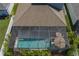 Aerial view of fenced in back yard, with a screened in pool, an umbrella and seating at 10914 Blue Magnolia Ln, Parrish, FL 34219
