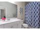 Bright bathroom featuring white vanity, large mirror, and stylish blue patterned shower curtain at 10914 Blue Magnolia Ln, Parrish, FL 34219