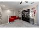 Cozy bonus room with a red sectional couch and shelves filled with books and decorative items at 10914 Blue Magnolia Ln, Parrish, FL 34219