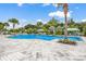 Resort-style community pool surrounded by lounge chairs, lush landscaping, and covered seating areas at 10914 Blue Magnolia Ln, Parrish, FL 34219