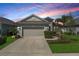 Charming one-story home featuring a two-car garage, well-manicured landscaping, and a welcoming front facade at 10914 Blue Magnolia Ln, Parrish, FL 34219