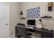 Inviting home office with desk, modern computer, and decorative wall shelves in neutral decor at 10914 Blue Magnolia Ln, Parrish, FL 34219