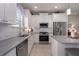 Kitchen featuring stainless steel appliances, granite countertops, white cabinets and tile floors at 10914 Blue Magnolia Ln, Parrish, FL 34219