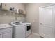 Practical laundry room featuring a modern washer and dryer, a utility sink, and convenient shelving for supplies at 10914 Blue Magnolia Ln, Parrish, FL 34219