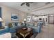 Comfortable living room open to the kitchen, featuring blue sofas, a ceiling fan and neutral walls at 10914 Blue Magnolia Ln, Parrish, FL 34219