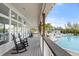 Clubhouse porch featuring rocking chairs, swimming pool, and tropical views of the landscaping at 121 Tidy Island Blvd, Bradenton, FL 34210