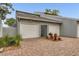 Exterior elevation of townhome with two-car garage and brick paver driveway, complemented by lush landscaping at 1249 Dockside Pl # 110, Sarasota, FL 34242