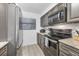 Kitchen with stainless steel appliances, tile backsplash, gray cabinets and stone countertops at 1249 Dockside Pl # 110, Sarasota, FL 34242