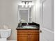 Charming bathroom featuring a granite countertop, vanity with a mirror, and decorative light fixture above the sink at 12622 Safe Harbour Dr, Cortez, FL 34215