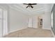 A large bedroom has plush carpet and neutral paint, white baseboards and archway to another room at 12622 Safe Harbour Dr, Cortez, FL 34215