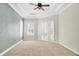 Spacious bedroom featuring tray ceilings, a ceiling fan, neutral carpeting, and large windows with white shutters at 12622 Safe Harbour Dr, Cortez, FL 34215