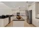 Spacious kitchen featuring stainless steel appliances, dark countertops and center island at 12622 Safe Harbour Dr, Cortez, FL 34215
