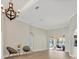 Open-concept living area with luxury vinyl floors and sliding glass doors to the lanai beyond at 12622 Safe Harbour Dr, Cortez, FL 34215