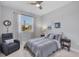 Cozy bedroom featuring a ceiling fan, a comfortable armchair, and natural light from the window at 1313 Kacerik St, North Port, FL 34288