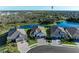 A view from above showcases three homes, green lawns, and a large pond at 13630 Deep Blue Pl, Bradenton, FL 34211