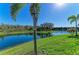 Lush green grass meets the pond in this backyard paradise with blue skies above at 13630 Deep Blue Pl, Bradenton, FL 34211