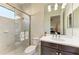 Bathroom with a marble-tiled shower, undermount sink and a large mirror reflecting the bedroom beyond at 13630 Deep Blue Pl, Bradenton, FL 34211