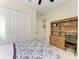Neutral-toned bedroom with a wooden hutch, closet, and doorway to the bathroom at 13630 Deep Blue Pl, Bradenton, FL 34211