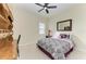 Cozy bedroom featuring a ceiling fan, shuttered window, and wood desk at 13630 Deep Blue Pl, Bradenton, FL 34211