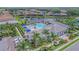 Aerial view of community pool, lake, and clubhouse in a beautiful residential area with lush landscaping and parking at 13630 Deep Blue Pl, Bradenton, FL 34211