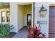 The covered entryway features a brick path, and a large dark-bronze lantern-style wall sconce at 13630 Deep Blue Pl, Bradenton, FL 34211