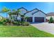 Charming two-story home features a three-car garage, paver driveway, and lush tropical landscaping at 13630 Deep Blue Pl, Bradenton, FL 34211