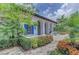 Exterior of a modern clubhouse featuring an arched entryway, blue shutters, and lush tropical landscaping at 13630 Deep Blue Pl, Bradenton, FL 34211