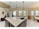 Kitchen island with sink and bar seating, flowing to the breakfast nook and outdoor grill at 13630 Deep Blue Pl, Bradenton, FL 34211