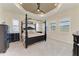 Inviting main bedroom with a tray ceiling, large windows with shutters, and neutral paint at 13630 Deep Blue Pl, Bradenton, FL 34211
