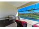 Outdoor kitchen with a grill, sink, and scenic backyard view of the pool and pond at 13630 Deep Blue Pl, Bradenton, FL 34211