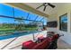 Covered outdoor patio with a pool, outdoor lounge furniture, and a serene water view at 13630 Deep Blue Pl, Bradenton, FL 34211