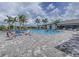 Community pool area with lounge chairs, palm trees, and a clubhouse in the background at 13630 Deep Blue Pl, Bradenton, FL 34211