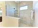 Walk-in shower featuring marble tile, glass enclosure, rainfall shower head, and tiled bench at 13630 Deep Blue Pl, Bradenton, FL 34211