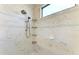 Close-up of shower with marble tiling, rainfall shower head, and built-in shower caddies at 13630 Deep Blue Pl, Bradenton, FL 34211