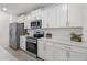 Elegant kitchen with stainless steel appliances, ample counter space, and sleek white cabinetry at 13977 Lilac Sky Ter, Bradenton, FL 34211