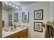 Classic bathroom with a bright vanity area, decorative artwork, and framed mirrors at 1760 Gulf Blvd # 603, Englewood, FL 34223
