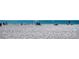 Panoramic view of a sandy beach and ocean with beachgoers under umbrellas at 1760 Gulf Blvd # 603, Englewood, FL 34223