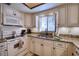 Cozy kitchen features white cabinetry, granite counters, double sink, and modern appliances at 1760 Gulf Blvd # 603, Englewood, FL 34223