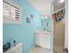 Bright bathroom with a shower, and a vanity with storage space featuring decorations on the colorful blue walls at 204 N Washington Dr, Sarasota, FL 34236