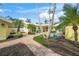 Charming home exterior with lush landscaping, palm trees, and a brick walkway leading to a double door entrance at 204 N Washington Dr, Sarasota, FL 34236