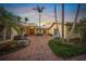 Inviting home exterior with lush landscaping, palm trees, and a brick walkway leading to a double door entrance at 204 N Washington Dr, Sarasota, FL 34236