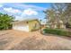 Charming yellow house with a brick driveway, lush greenery, and an attached two-car garage at 204 N Washington Dr, Sarasota, FL 34236