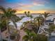 Stunning waterfront home with tropical landscaping, updated white roof and paver driveway at sunset at 204 N Washington Dr, Sarasota, FL 34236