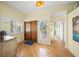 Bright foyer featuring hardwood floors, double doors with shuttered windows, and a view down the hallway at 204 N Washington Dr, Sarasota, FL 34236