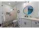 Modern bathroom with a glass shower, white cabinets, quartz countertop, and stylish patterned tile flooring at 211 81St St # B, Holmes Beach, FL 34217
