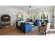 Sun-drenched living room featuring comfortable blue couches, bright walls, ceiling fan, and outdoor balcony at 211 81St St # B, Holmes Beach, FL 34217